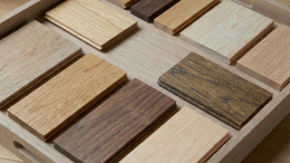 Wooden flooring samples in various colours arranged on a tray